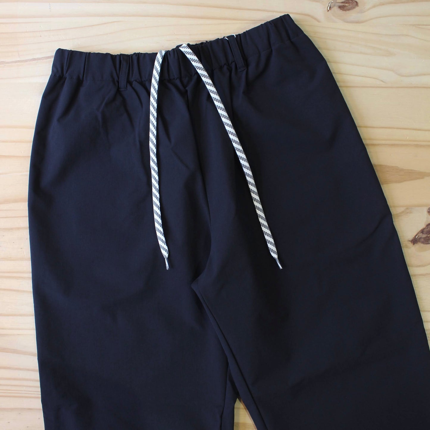 MANUAL ALPHABET -
4WAY NYLON EASY TAPERED PANTS